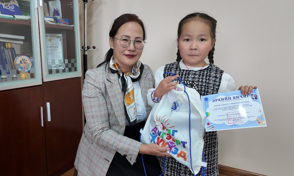 
Хүүхэд, гэр бүлийн хөгжил, хамгааллын газрын 2024 онд баталсан байгууллагын "Дотоод журам"-ын 8.3.7-д “Албан хаагчдын хүүхэд 1 дүгээр ангид элсэн орж байгаа, мөн 12 дугаар ангиа төгсөж байгаа тохиолдолд байгууллагаас нэг удаа дурсгалын зураг авахуулах зардлыг хариуцна” гэж тусгасны дагуу 2025-2026 оны хичээлийн жилд 1 дүгээр ангид элсэн суралцах 6 хүүхдэд эрхийн бичиг болон гарын бэлэг гардууллаа.
Энэхүү арга хэмжээ нь байгууллагын зүгээс ажилтан, албан хаагчдынхаа үр хүүхдийн сурч боловсрох үйлсийг дэмжих, гэр бүлд ээлтэй бодлогыг хэрэгжүүлэх, хүүхдийнхээ амьдралын чухал мөчүүдийг үнэ цэнэтэй дурсамж болгон үлдээхэд нь туслах зорилготой юм.
Мөн Дотоод журмын 7.2.12-т заасны дагуу цэцэрлэгийн насны 2-5 настай болон 1 дүгээр ангид элсэн орж буй хүүхэдтэй албан хаагчдад хүүхдээ хүргэх зорилгоор 2 цагийн чөлөө олгохоор тусгасан.
Энэхүү зохицуулалтыг байгууллага нийтээрээ мөрдлөг болгон ажиллаж, ажилтан албан хаагчдын нийгмийн баталгааг хангах, хүүхдийнхээ сургууль, цэцэрлэгт дасан зохицох үйл явцад эцэг эхийн оролцоог нэмэгдүүлэх, гэр бүлд ээлтэй ажлын орчин бүрдүүлэх бодлогын хүрээнд хэрэгжүүлнэ.
